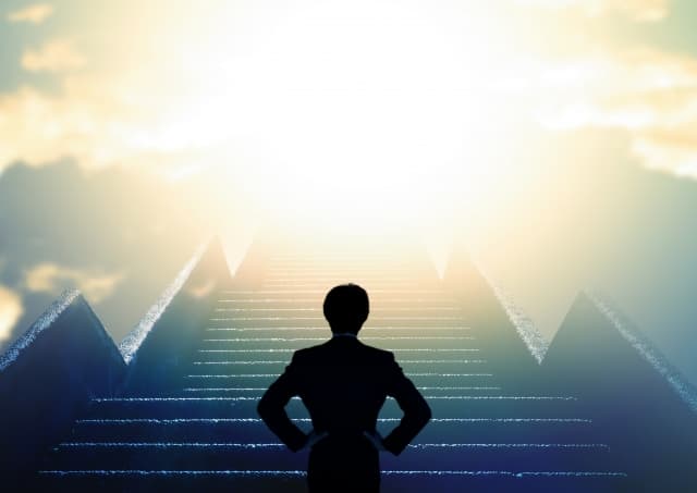 光に向かって立っている男性